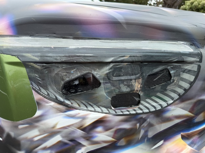 Headlight detail of a camouflaged Bentley Torcal EV prototype