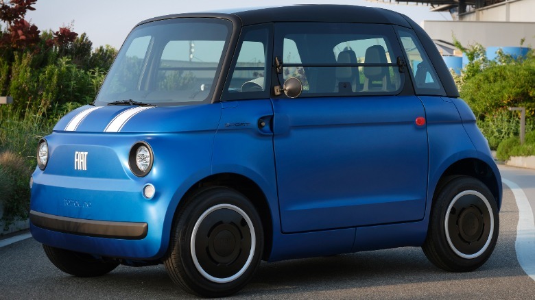 front three-quarters shot of a blue Topolino Sport parked on a road next to bushes