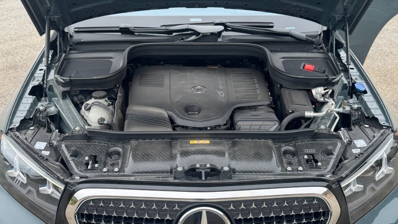 An underhood shot of the GLE450 Coupe's six-cylinder engine with some gravel visible behind it
